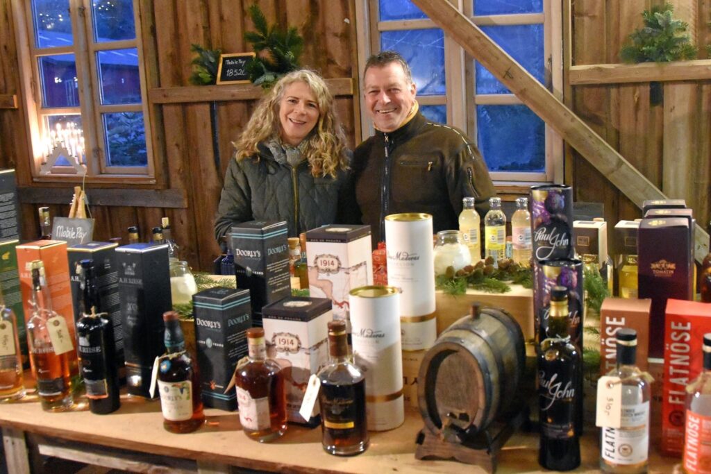 Par står bag bod med lokale delikatesser og flasker